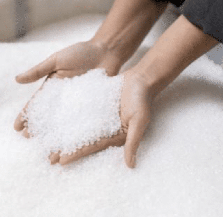 hands holding white plastic pellets